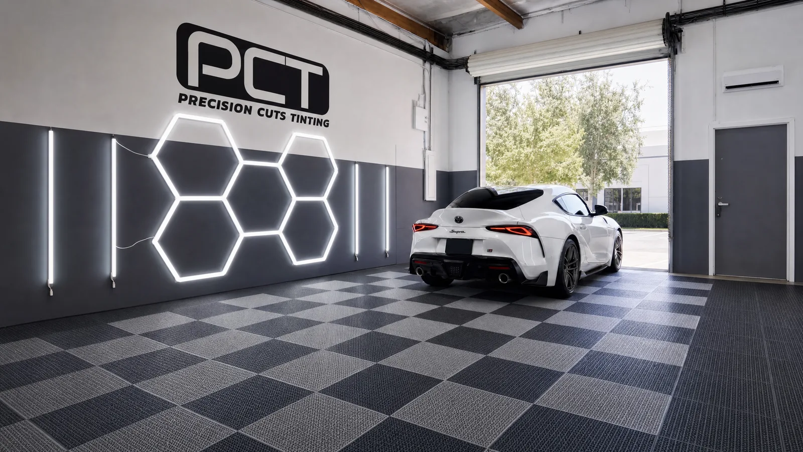A white Toyota GR Supra, freshly tinted, rolling out through our studio’s roller door