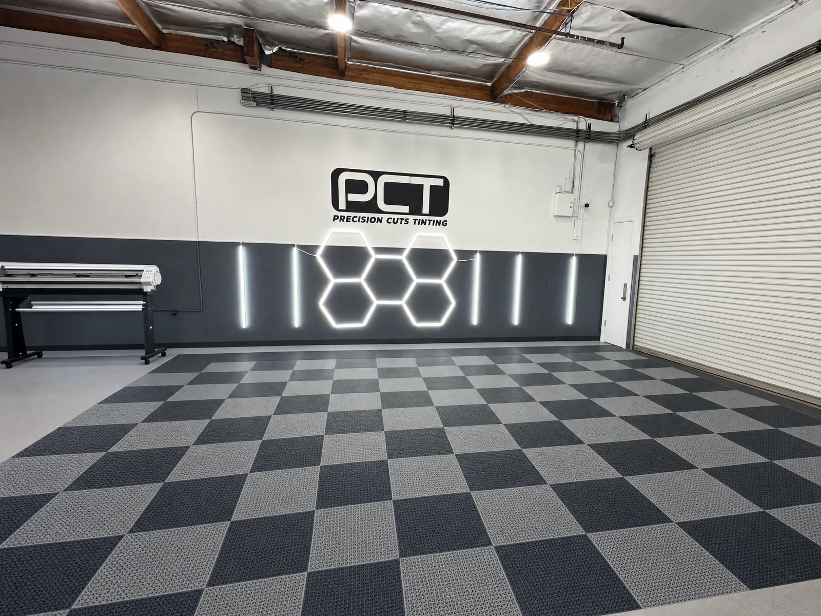 Inside the Precision Cuts Tinting studio in Yorba Linda: the PCT wall, the film plotter and the checkered floor