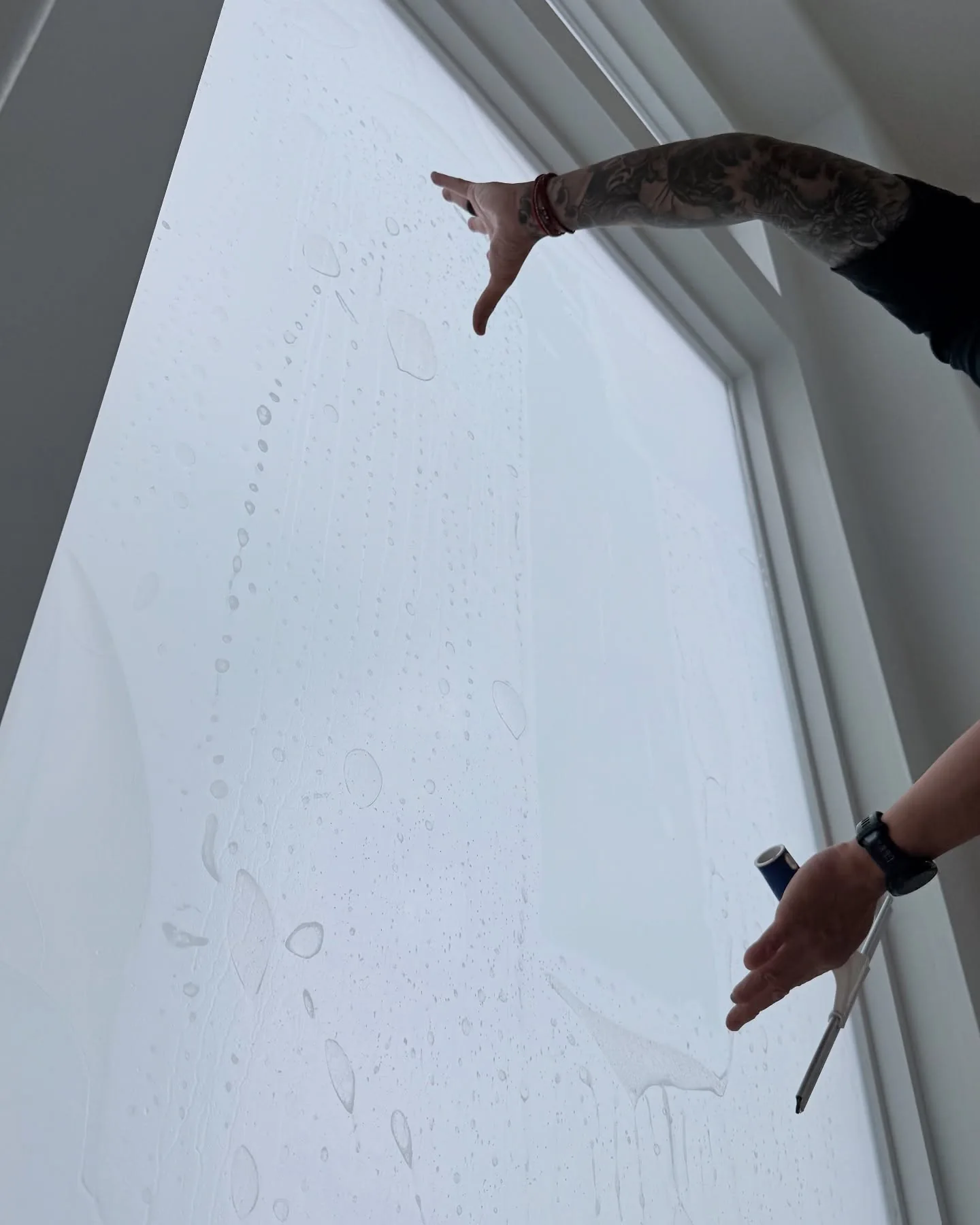 Privacy film being smoothed onto a window by one of our installers